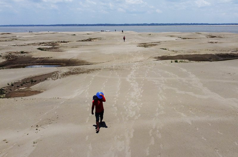 FILE - Residents of a riverside community carry food and containers of drinking water from an aid distribution due to the ongoing drought in Careiro da Varzea, Amazonas state, Brazil, Oct. 24, 2023. Earth last year shattered global annual heat records, the European climate agency said Tuesday, Jan. 9, 2024. (AP Photo /Edmar Barros, File)